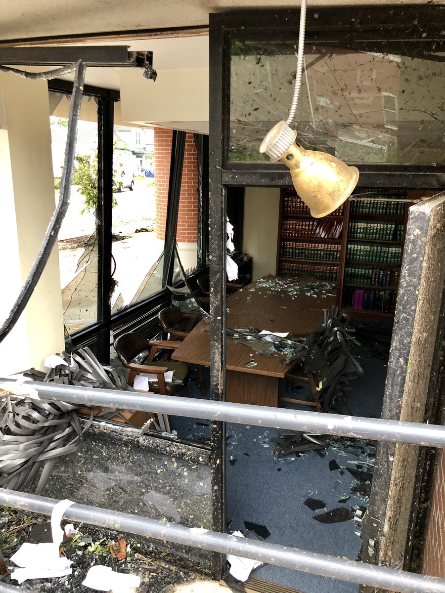 All windows in this room are blown out and shards of glass sit in piles on the table.